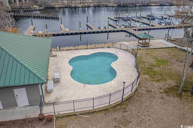 view of pool with a water view, a dock, and a patio area