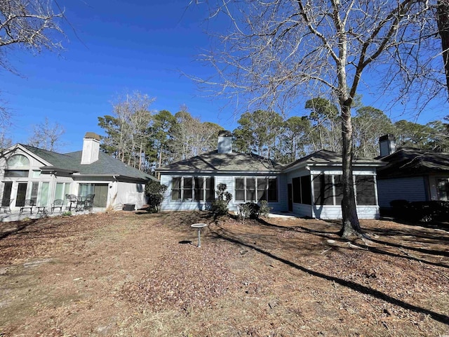 rear view of property featuring a sunroom