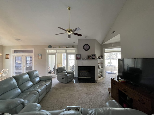 living room featuring ceiling fan, plenty of natural light, high vaulted ceiling, and light carpet