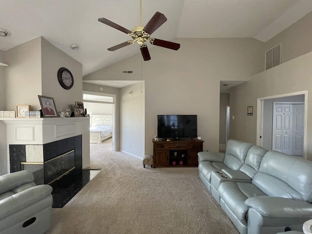 carpeted living room with a high end fireplace, high vaulted ceiling, and ceiling fan