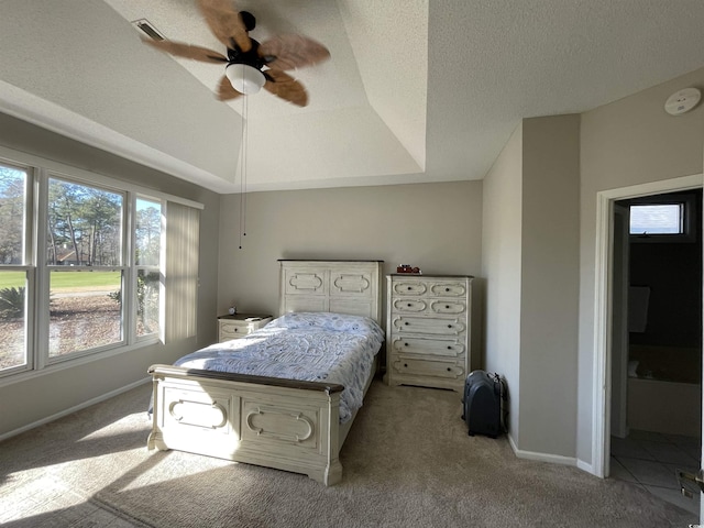 carpeted bedroom with a raised ceiling, ceiling fan, and a textured ceiling