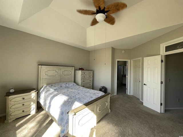 carpeted bedroom with ceiling fan, a tray ceiling, and vaulted ceiling