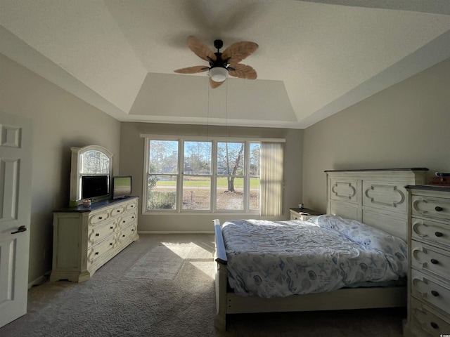 carpeted bedroom featuring vaulted ceiling, ceiling fan, and a tray ceiling