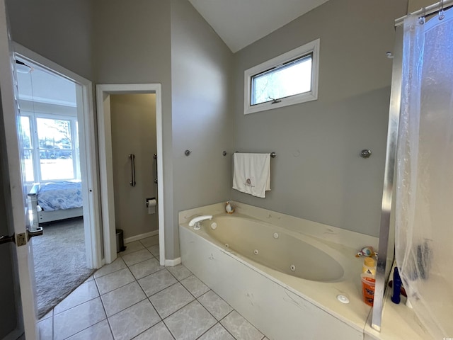 bathroom featuring tile patterned flooring, lofted ceiling, and a washtub