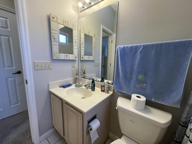 bathroom with tile patterned flooring, vanity, and toilet