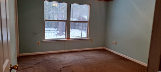 spare room with baseboards and carpet flooring