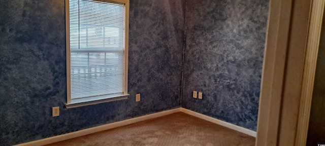 carpeted empty room with baseboards