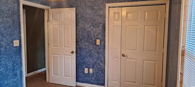 unfurnished bedroom featuring wallpapered walls and baseboards