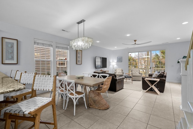 tiled dining area featuring ceiling fan with notable chandelier