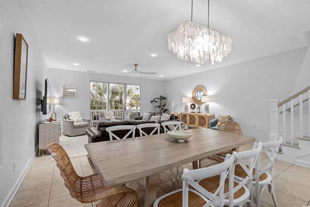 tiled dining room with ceiling fan with notable chandelier