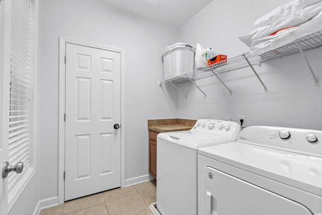 laundry area featuring cabinets, separate washer and dryer, and light tile patterned floors