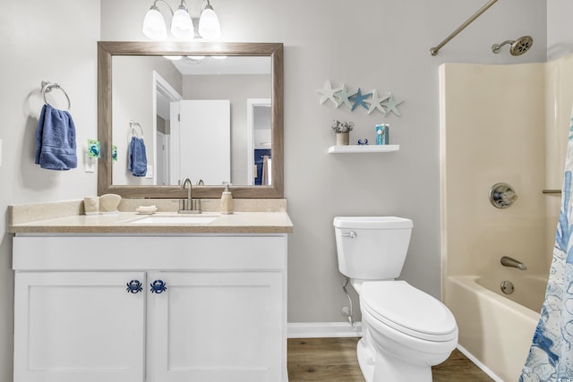 full bath featuring vanity, wood finished floors, baseboards, shower / bath combo with shower curtain, and toilet