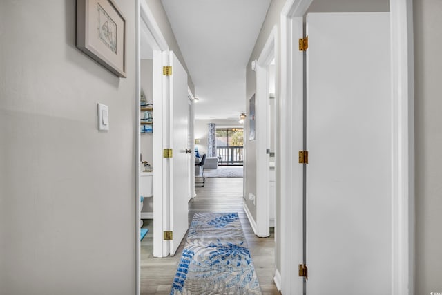 hall featuring wood finished floors and baseboards