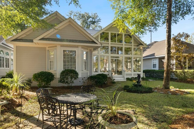 back of house featuring a yard and a sunroom