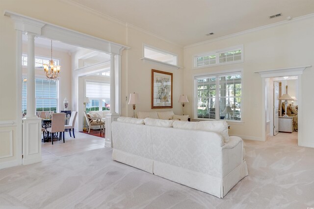 living area with crown molding, decorative columns, and a wealth of natural light