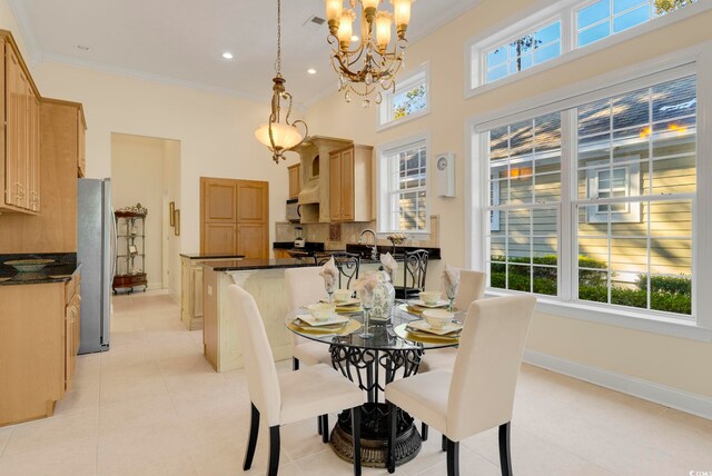 tiled dining room with crown molding, sink, and an inviting chandelier