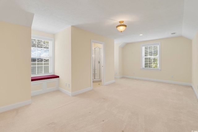 carpeted spare room with vaulted ceiling