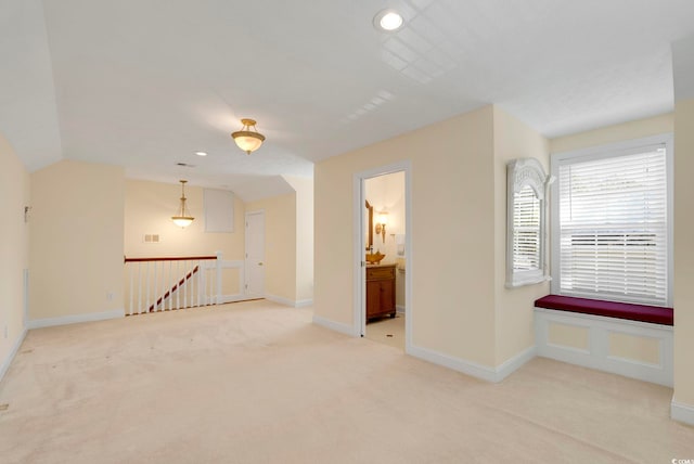 carpeted empty room with vaulted ceiling