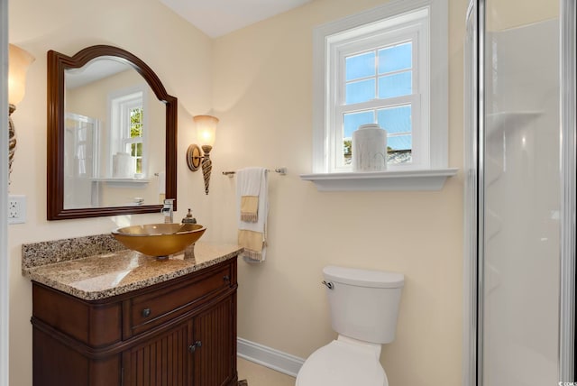 bathroom featuring vanity, plenty of natural light, a shower with door, and toilet