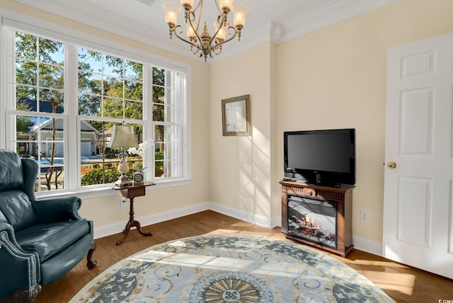 sitting room featuring crown molding, plenty of natural light, hardwood / wood-style flooring, and a notable chandelier