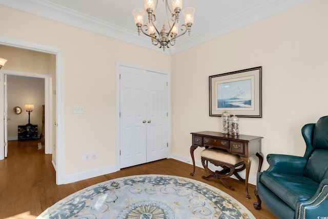 sitting room with ornamental molding, dark hardwood / wood-style flooring, and a notable chandelier