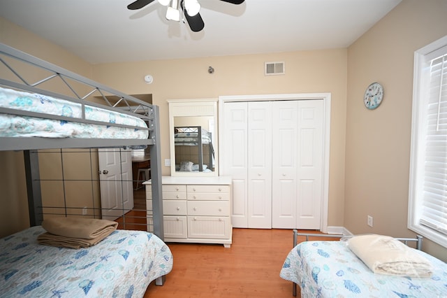 bedroom featuring hardwood / wood-style flooring, ceiling fan, and a closet