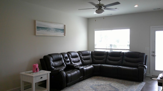 living area with ceiling fan, wood finished floors, and visible vents