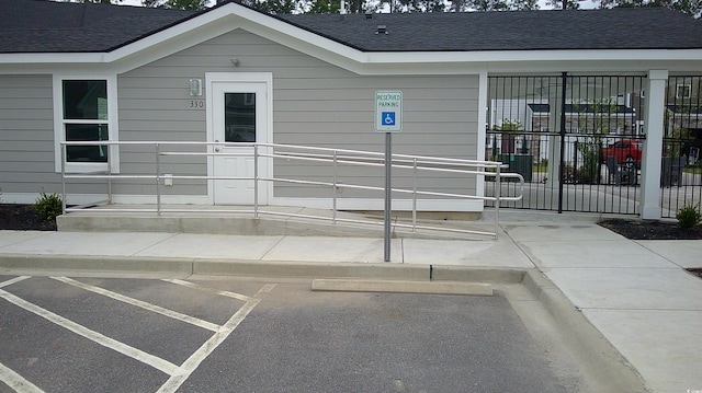 exterior space featuring a shingled roof and fence