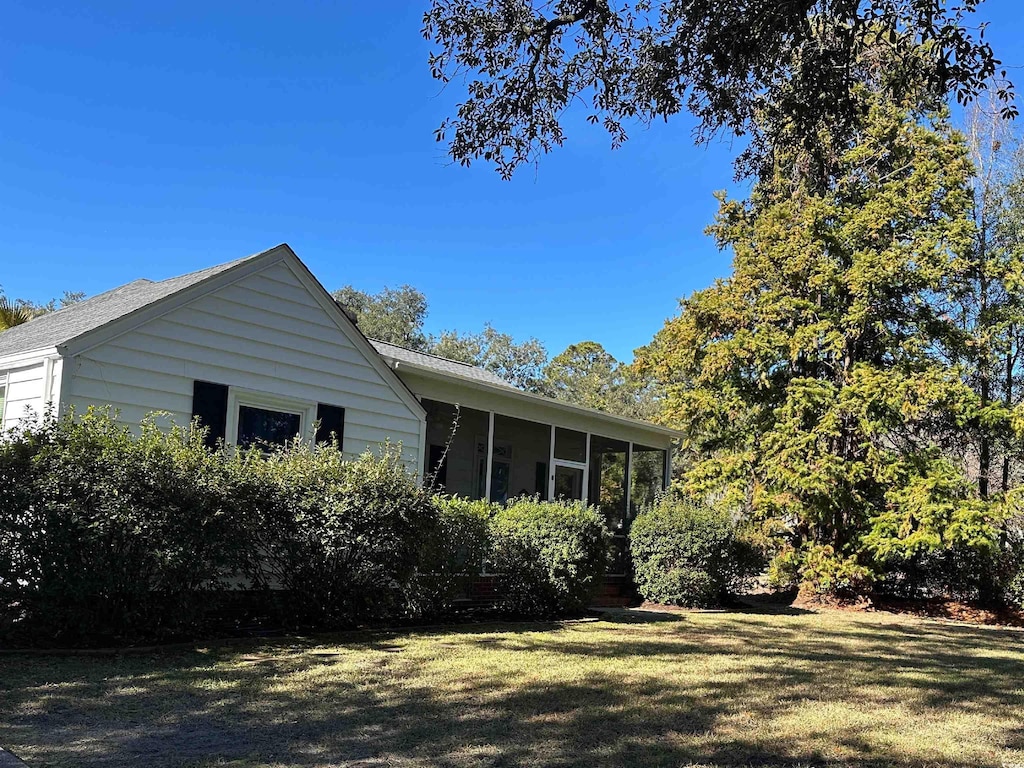 view of property exterior featuring a yard and a sunroom