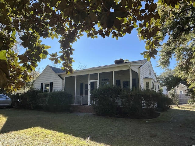 view of front facade with a sunroom and a front yard