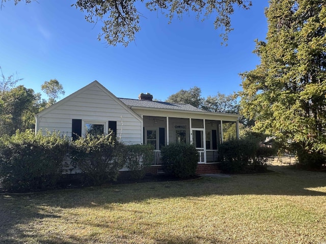 view of front of property featuring a sunroom and a front yard