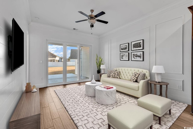 living room featuring crown molding, ceiling fan, and wood-type flooring