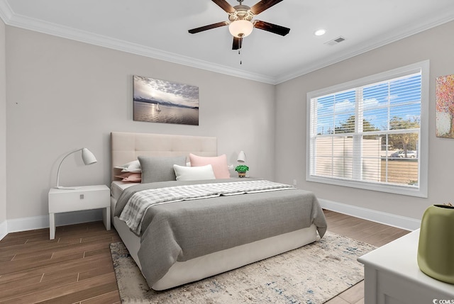 bedroom with hardwood / wood-style flooring, ornamental molding, and ceiling fan