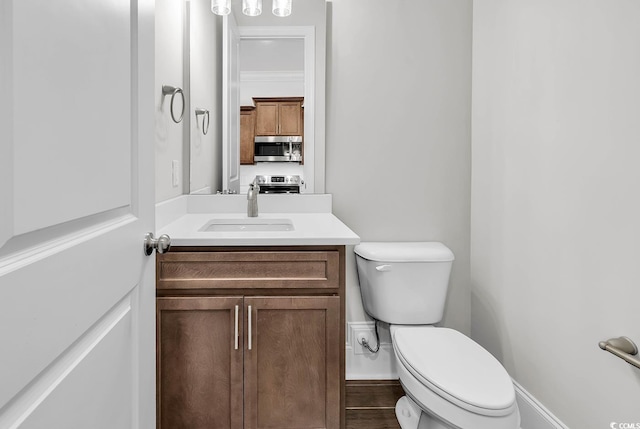 bathroom with hardwood / wood-style flooring, vanity, and toilet