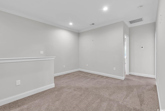 empty room featuring ornamental molding and light carpet