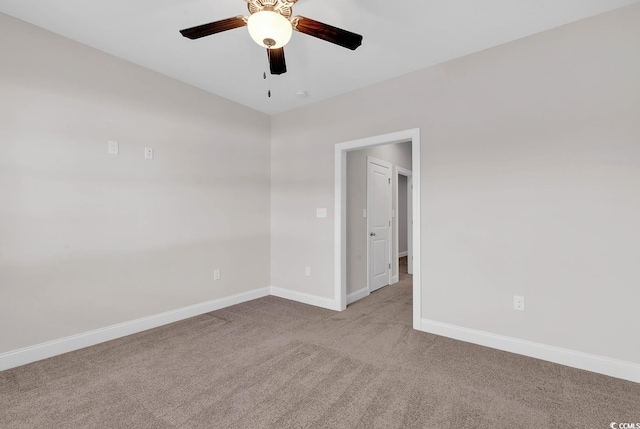 carpeted spare room featuring ceiling fan