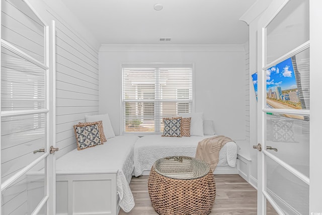 bedroom with ornamental molding and light wood-type flooring