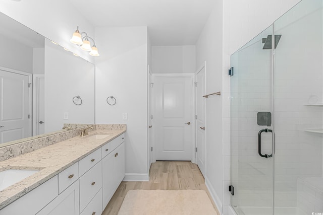 bathroom featuring hardwood / wood-style flooring, vanity, and an enclosed shower