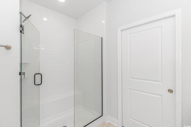 bathroom featuring a shower with door