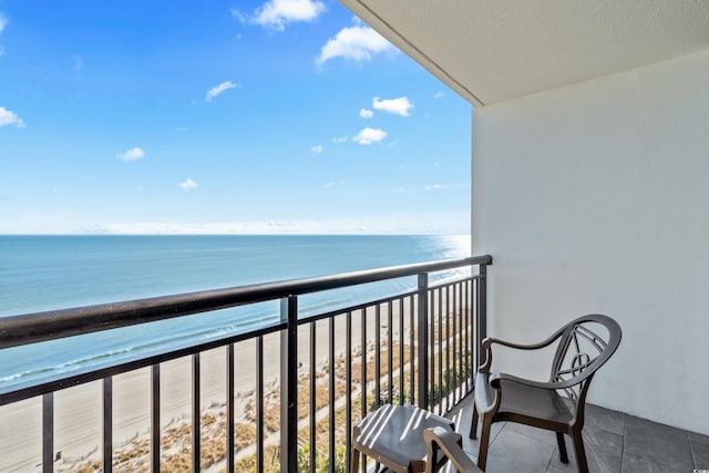 balcony featuring a water view and a beach view