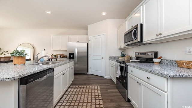 kitchen with sink, dark wood-type flooring, stainless steel appliances, light stone countertops, and white cabinets