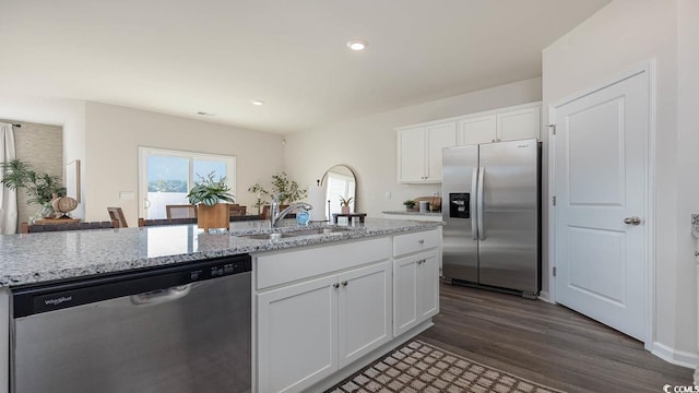 kitchen featuring appliances with stainless steel finishes, dark hardwood / wood-style floors, white cabinets, and light stone counters