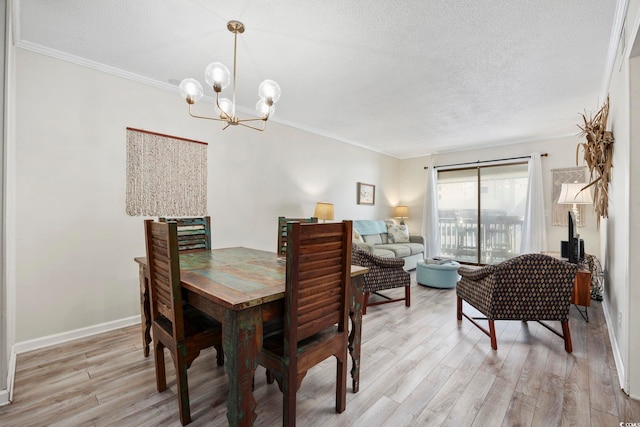 dining space with a notable chandelier, crown molding, and light hardwood / wood-style floors