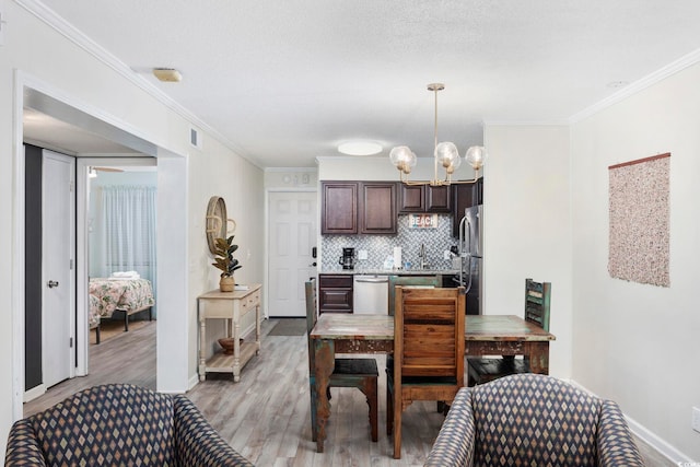 kitchen featuring hanging light fixtures, crown molding, dark brown cabinetry, and decorative backsplash