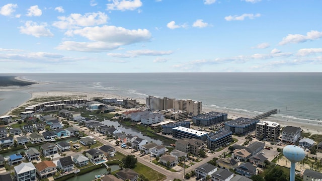 birds eye view of property with a water view and a beach view