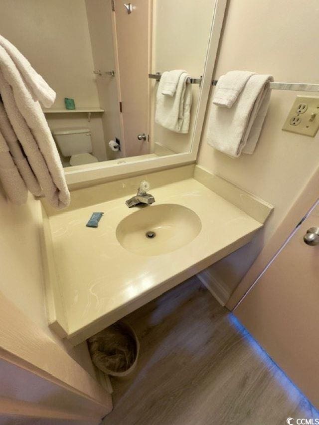 bathroom featuring sink, wood-type flooring, and toilet