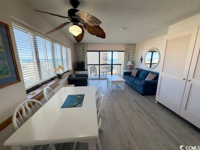 dining space with ceiling fan, light hardwood / wood-style flooring, and a textured ceiling