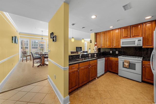 kitchen with pendant lighting, sink, light colored carpet, kitchen peninsula, and white appliances