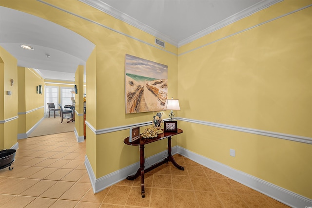 hall with ornamental molding and tile patterned floors