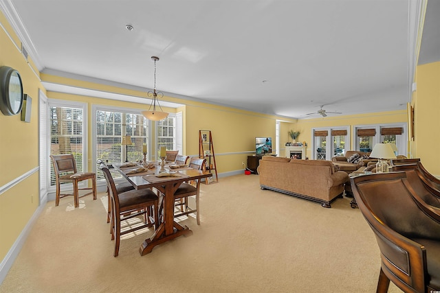 carpeted dining room featuring crown molding, plenty of natural light, and ceiling fan